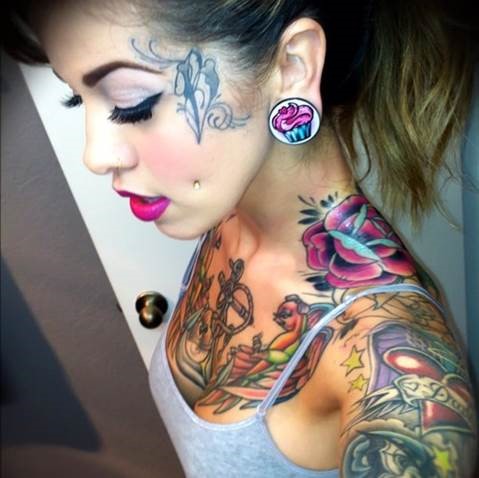 Woman with colorful tattos and piercings.